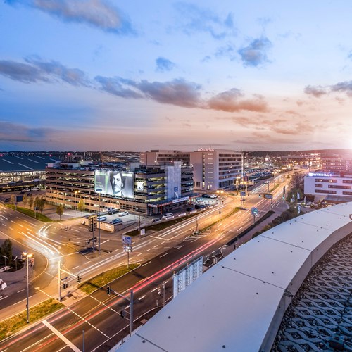 Blick vom SkyLoop auf Terminal und Parkhäuser im Sonnenuntergang