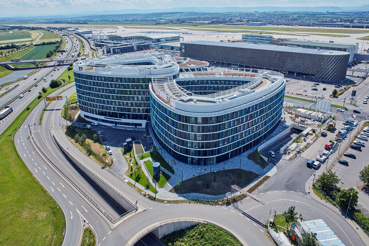 Luftbild eines Bürogebäudes neben der Autobahn und dem Flughafen