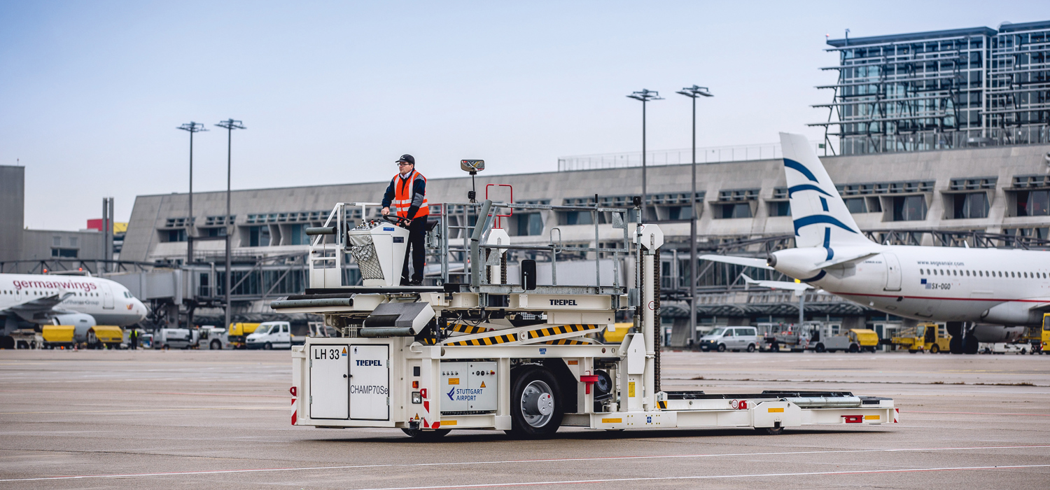 Ein elektrisch betriebener Highloader steht mit seinem Fahrer auf dem Stuttgarter Flughafenvorfeld. 