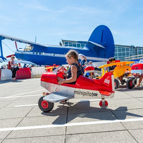 Kinder fahren mit Miniflugzeugen auf der Besucherterrasse