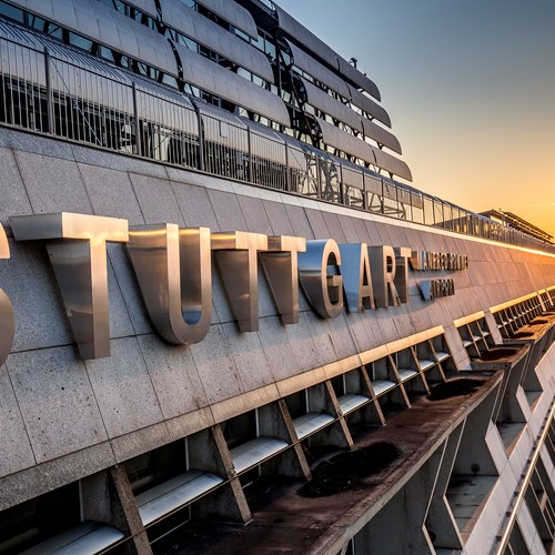 Schriftzug Stuttgart Airport auf der Fassade des Terminalgebäudes bei Sonnenaufgang