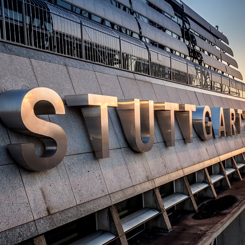 Schriftzug Stuttgart Airport auf der Fassade des Terminalgebäudes bei Sonnenaufgang
