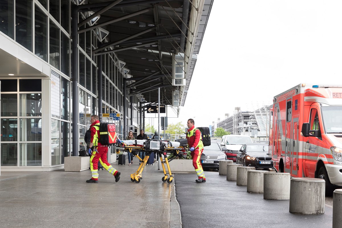 Sanitäter mit Trage und Ausrüstung auf dem Weg zum Einsatz im Terminal