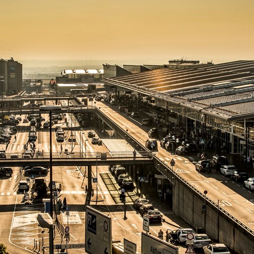 Terminalvorfahrten und Parkplätze neben den Gebäuden im Sonnenlicht mit vielen Autos