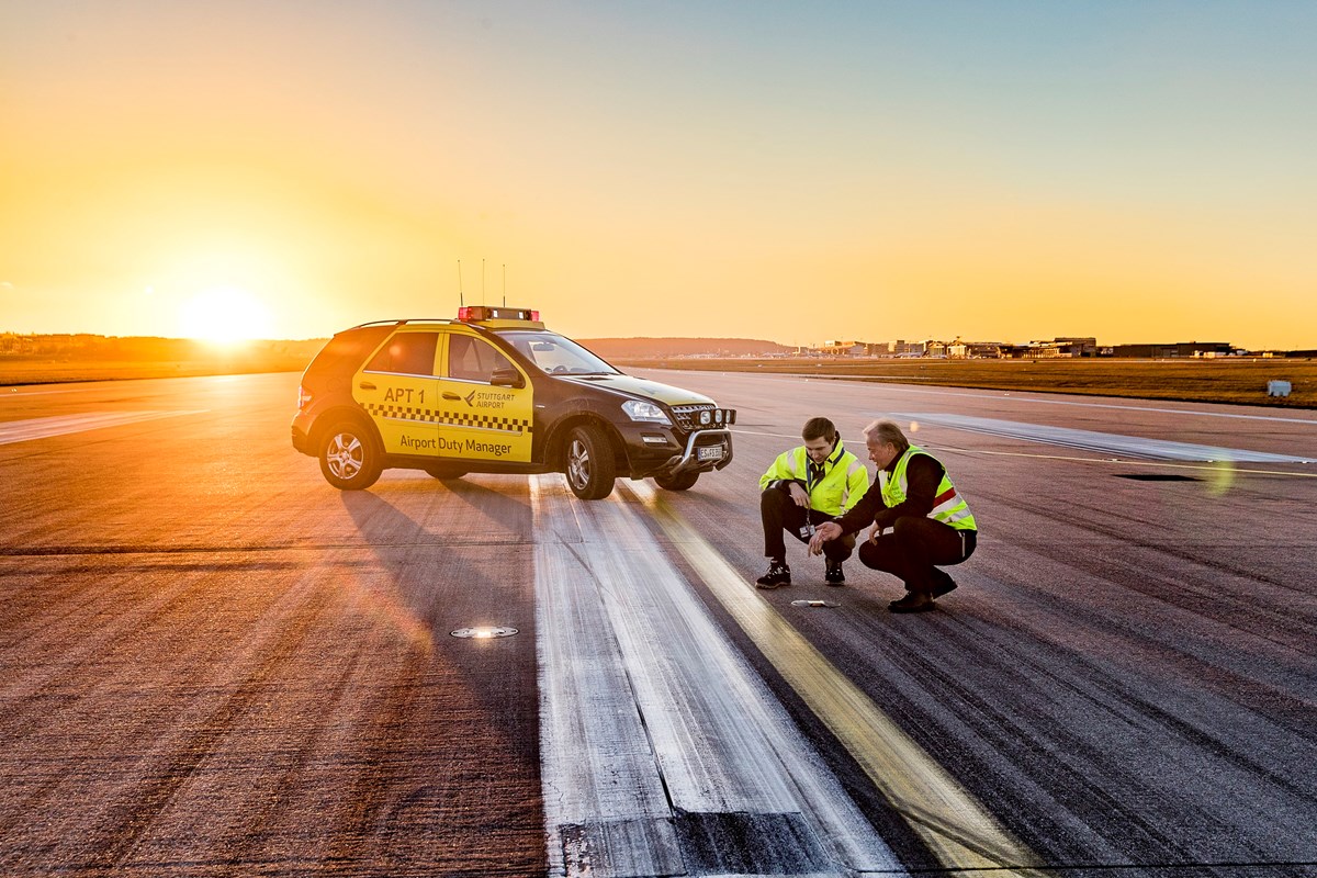 Zwei Airport Duty Manager prüfen bei Sonnenuntergang die Runway-Befeuerung am Boden. 