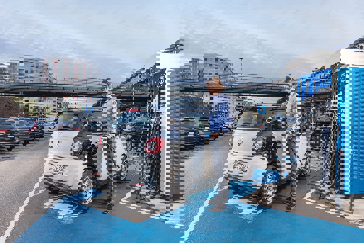 Studierender Bachelor of Engineering Umwelt und Energie steht vor E-Auto 